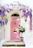 A serene Dartford entranceway is captured at that perfect moment when flowers make a new house feel instantly like a home. The pale pink front door, painted in a soft pastel that looks almost brushed with chalk, stands as the calm heart of the scene, flanked by whitewashed walls that reflect a mild, flattering daylight. Arcing above and trailing down the sides, mature wisteria spills in generous clusters, its lavender and lilac blooms cascading like ribbons of colour you might see tumbling over a garden arch near Central Park on a late spring afternoon. The blossoms hang densely, yet with a relaxed, natural fall, suggesting both abundance and ease. At the doorstep, slightly to one side, rests a weathered grey bucket transformed into a graceful floral display. It is filled to overflowing with creamy white roses at full bloom, each flower soft and rounded, with petals layered in spirals that invite a closer look. Fresh green foliage peeks between the roses, offering a gentle contrast and adding the sense of something just cut and arranged by hand. A satin pink ribbon encircles the bucket, tied carefully with trailing ends that echo the soft hues of both the door and the wisteria. Subtle shadows and highlights across stone, metal, and petals create depth and quiet movement, as if the light is slowly shifting toward evening. The mood suggests a housewarming gift delivered across Dartford's neighbourhoods-a tender floral gesture that celebrates new beginnings, offers congratulations, and promises a warm, floral welcome every time someone steps up to that door.